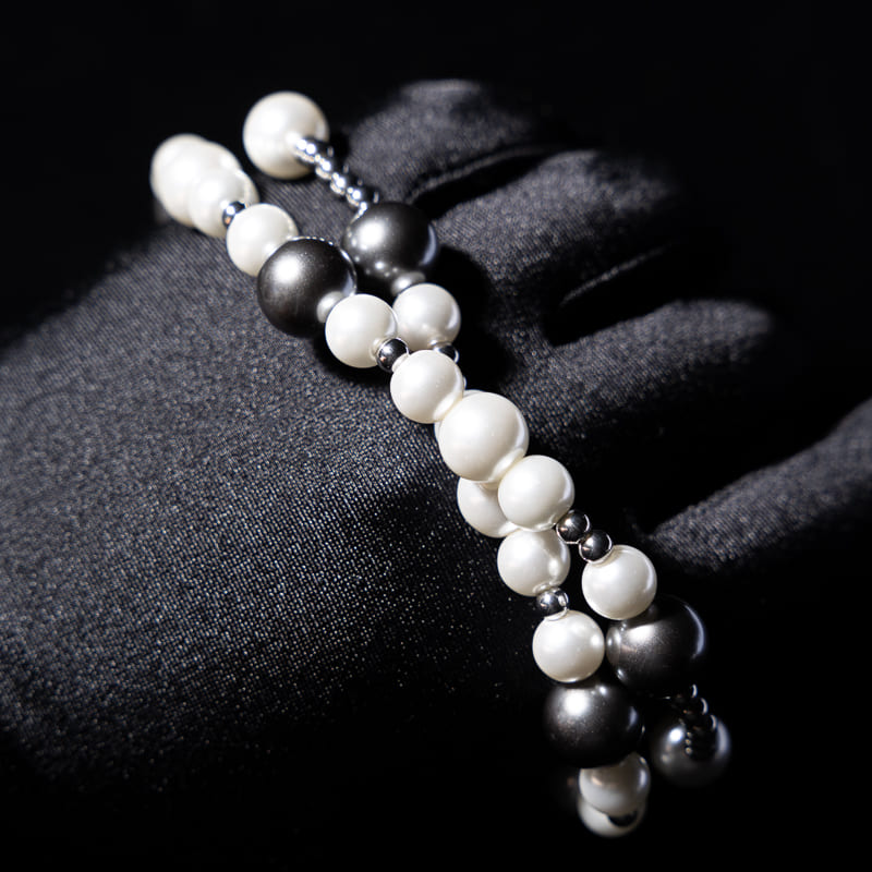 White pearls on the black silk as background, Stock image